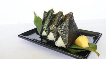 onigiri es comida japonesa, bola de arroz japonesa, triángulo de arroz con algas, nori aislado con fondo foto