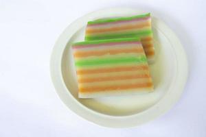 lapis cake or roti lapis or layer cake or lapis legit served in little plate isolated on white background made from rice flour, starch, coconut milk, sugar, salt and coloring photo