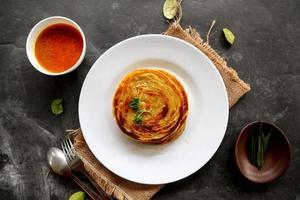 paratha bread or canai bread or roti maryam, favorite breakfast dish. served on plate photo