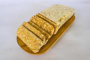 Raw tempeh or tempe. tempeh slices in white background. raw soybean seeds. Tempe is a traditional Indonesian food made from fermented soybeans. photo
