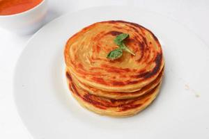 paratha bread or canai bread or roti maryam, favorite breakfast dish. served on plate photo