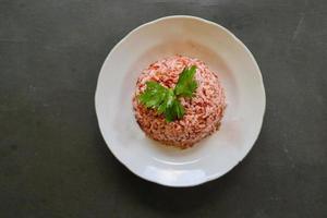 Red steamed rice or nasi merah served in plate isolated on black background photo