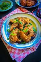 Delicious homemade crispy fried chicken with spicy taste and lemon on plate photo