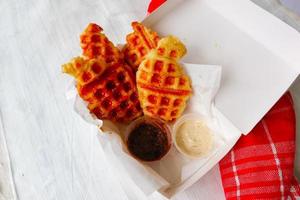 Croissant Waffle or Croffle with chocolate sauce served in box and white background photo