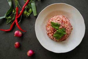 Red steamed rice or nasi merah served in plate isolated on black background photo