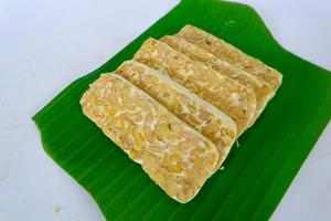 Raw tempeh or tempe. tempeh slices in white background. raw soybean seeds. Tempe is a traditional Indonesian food made from fermented soybeans. photo