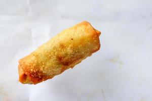 Lumpia or lunpia, is traditional spring roll skin snack from Semarang, Indonesia. Traditional Spring rolls made eggs, and chicken or shrimp, stir-fried bamboo shoots. isolated on white background photo