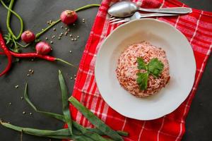 Red steamed rice or nasi merah served in plate isolated on black background photo