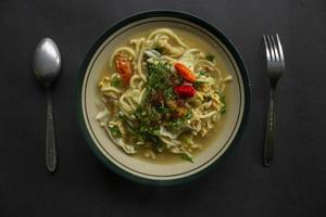 Mie godog Jawa or bakmi jawa or java noodle or Mie rebus or boiled noodles with spoon and fork. Indonesian traditional street food noodles from java, indonesia on white backgroud photo