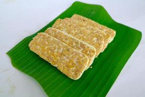Raw tempeh or tempe. tempeh slices in white background. raw soybean seeds. Tempe is a traditional Indonesian food made from fermented soybeans. photo