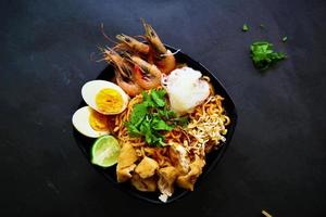 laksa, laksa curry made from vermicelli, noodles, bean sprouts, egg, tofu lime, and shrimp with a spicy soup sauce that is rich in spices. laksa served on bowl, isolated on white background. photo