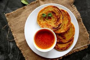 paratha bread or canai bread or roti maryam, favorite breakfast dish. served on plate photo