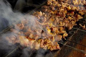 sate klatak or sate kambing or satay goat, lamb, Lamb or meat goat satay with charcoal ingredient on red fire grilling by people, Indonesia cooking satay. with selective focus photo