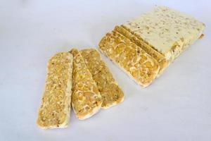 Raw tempeh or tempe. tempeh slices in white background. raw soybean seeds. Tempe is a traditional Indonesian food made from fermented soybeans. photo