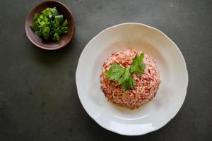 Red steamed rice or nasi merah served in plate isolated on black background photo