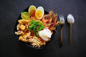 laksa, laksa curry made from vermicelli, noodles, bean sprouts, egg, tofu lime, and shrimp with a spicy soup sauce that is rich in spices. laksa served on bowl, isolated on white background. photo