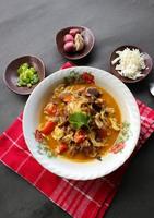 Goat Curry or gulai kambing, food from asia. Delicious goat meat curry served in a bowl.served with tomato, seasoning, celery and cabbage photo