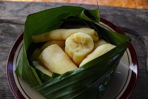 tapai o tape o peuyeum son alimentos tradicionales, bocadillos de indonesia, elaborados con yuca fermentada. servido en hoja de plátano foto