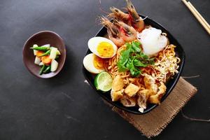 laksa, laksa curry made from vermicelli, noodles, bean sprouts, egg, tofu lime, and shrimp with a spicy soup sauce that is rich in spices. laksa served on bowl, isolated on white background. photo