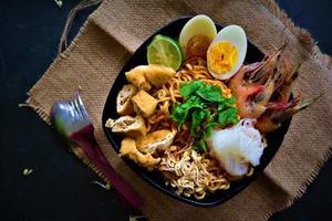 laksa, laksa curry made from vermicelli, noodles, bean sprouts, egg, tofu lime, and shrimp with a spicy soup sauce that is rich in spices. laksa served on bowl, isolated on white background. photo