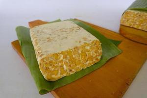 Raw tempeh or tempe. tempeh slices in white background. raw soybean seeds. Tempe is a traditional Indonesian food made from fermented soybeans. photo