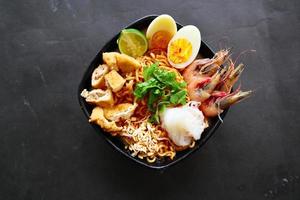 laksa, laksa curry made from vermicelli, noodles, bean sprouts, egg, tofu lime, and shrimp with a spicy soup sauce that is rich in spices. laksa served on bowl, isolated on white background. photo