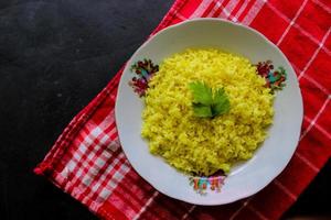 yellow rice or turmeric rice or nasi kuning is food made from rice cooked with turmeric, coconut milk and spices. so the taste is more savory photo