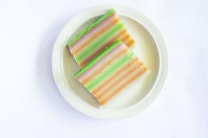 lapis cake or roti lapis or layer cake or lapis legit served in little plate isolated on white background made from rice flour, starch, coconut milk, sugar, salt and coloring photo