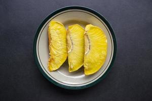 sukun goreng or fried breadfruit served at plate on black background photo