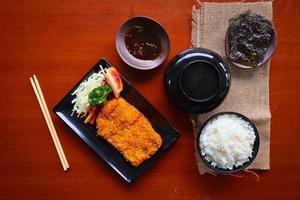 chicken katsu don is japanese food served with soy sauce on table photo