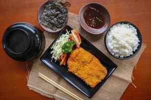 chicken katsu don is japanese food served with soy sauce on table photo