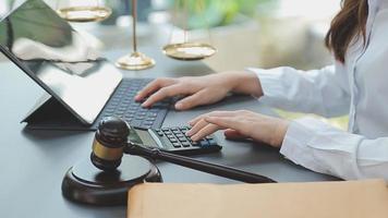 Business and lawyers discussing contract papers with brass scale on desk in office. Law, legal services, advice, justice and law concept picture with film grain effect video