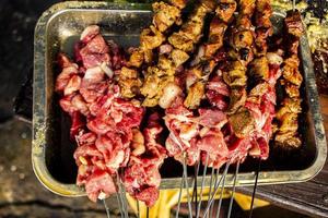sate klatak or sate kambing or satay goat, lamb, Lamb or meat goat satay with charcoal ingredient on red fire grilling by people, Indonesia cooking satay. with selective focus photo
