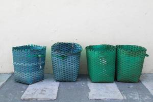 basket, plastic basket serves as a trash can.garbage trash can can outside against wall photo