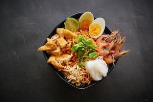 laksa, laksa curry made from vermicelli, noodles, bean sprouts, egg, tofu lime, and shrimp with a spicy soup sauce that is rich in spices. laksa served on bowl, isolated on white background. photo