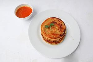 paratha bread or canai bread or roti maryam, favorite breakfast dish. served on plate photo