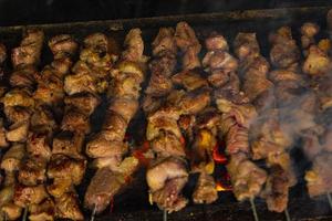 sate klatak or sate kambing or satay goat, lamb, Lamb or meat goat satay with charcoal ingredient on red fire grilling by people, Indonesia cooking satay. with selective focus photo