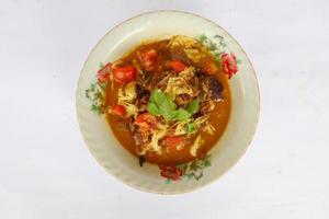 Goat Curry or gulai kambing, food from asia. Delicious goat meat curry served in a bowl.served with tomato, seasoning, celery and cabbage photo