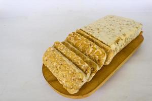 Raw tempeh or tempe. tempeh slices in white background. raw soybean seeds. Tempe is a traditional Indonesian food made from fermented soybeans. photo