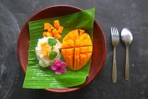 El arroz pegajoso de mango es un postre tailandés hecho de arroz pegajoso, mango y leche de coco. foto