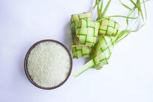 ketupat in earthenware plate isolated on white background. Ketupat Rice Dumpling is food served when idhul fitri eid mubarak in Indonesia, made from rice wrapped in young coconut leaves janur photo