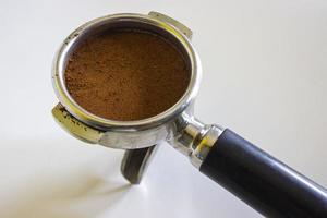 porta filter with ground coffee and coffee bean isolated from a white background photo