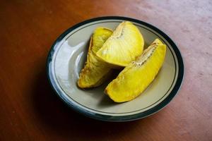 sukun goreng or fried breadfruit served at plate on black background photo