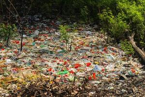 basura plástica derramada en la tierra de la gran ciudad. botellas de plástico sucias usadas vacías. contaminación plástica. contaminación ambiental. problema ecológico. foto
