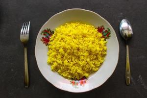 yellow rice or turmeric rice or nasi kuning is food made from rice cooked with turmeric, coconut milk and spices. so the taste is more savory photo