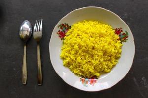 yellow rice or turmeric rice or nasi kuning is food made from rice cooked with turmeric, coconut milk and spices. so the taste is more savory photo