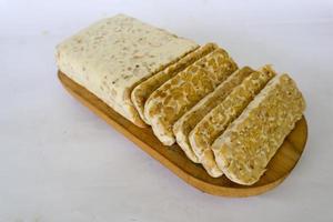 Raw tempeh or tempe. tempeh slices in white background. raw soybean seeds. Tempe is a traditional Indonesian food made from fermented soybeans. photo