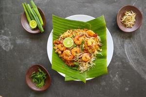 pad thai, o phad thai, es un plato de fideos de arroz salteado de tailandia. hecho de fideos de arroz, brotes de soja, huevos, gambas y especias tailandesas foto