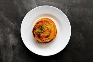 paratha bread or canai bread or roti maryam, favorite breakfast dish. served on plate photo