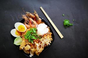 laksa, laksa curry made from vermicelli, noodles, bean sprouts, egg, tofu lime, and shrimp with a spicy soup sauce that is rich in spices. laksa served on bowl, isolated on white background. photo